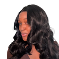 Woman with long, wavy hair wearing a brown top against a neutral background